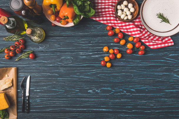pohled shora zeleniny a olejů na dřevěné tabulce v kuchyni - Fotografie, Obrázek