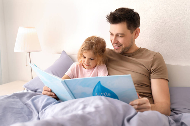 Father with little daughter reading bedtime story at home - Valokuva, kuva