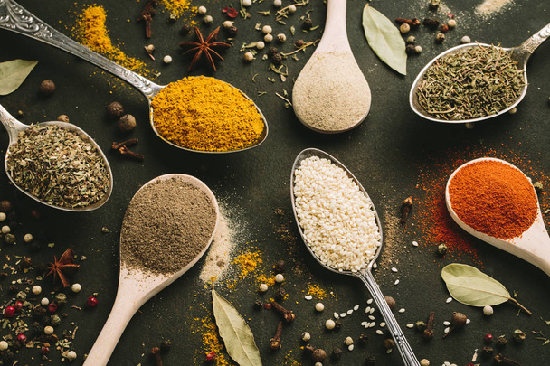 Spices and herbs over black stone background. - Foto, Imagem