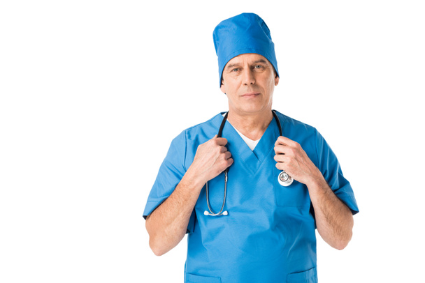 Médico masculino en estetoscopio de sujeción uniforme aislado en blanco
 - Foto, Imagen