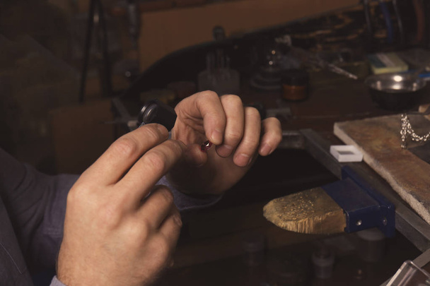 Jeweler examining gem in workshop - Foto, afbeelding