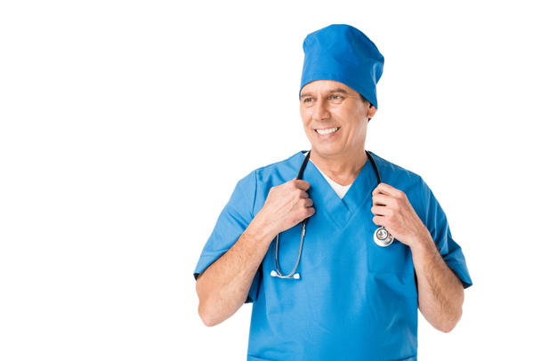 Médico sonriente con estetoscopio uniforme aislado en blanco
 - Foto, Imagen