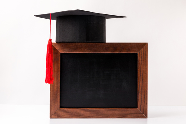Academic cup on empty blackboard isolated on white - Photo, Image