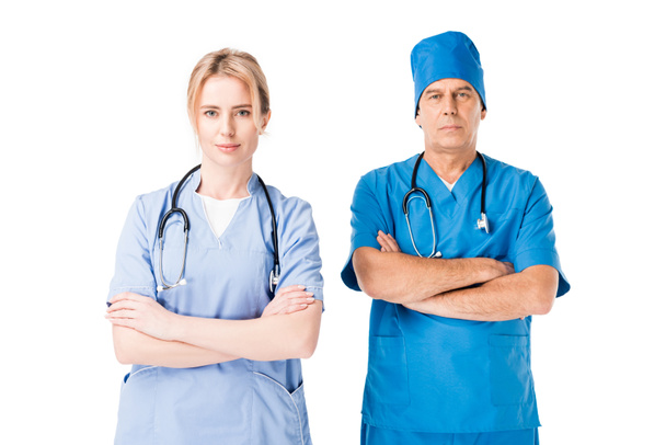 Medico infermiere e medico in uniforme con stetoscopi in piedi con le braccia incrociate isolate su bianco
 - Foto, immagini