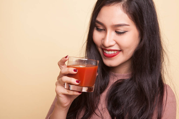 Asian woman with a clock drink orange juice. - Zdjęcie, obraz