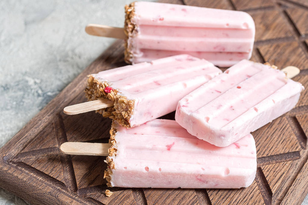 Yogurt, berry and granola breakfast popsicles on a tray - Foto, afbeelding