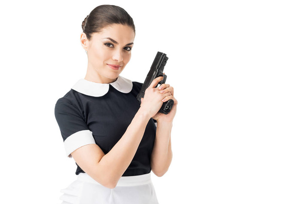 Young maid in uniform holding gun isolated on white - Foto, Imagem