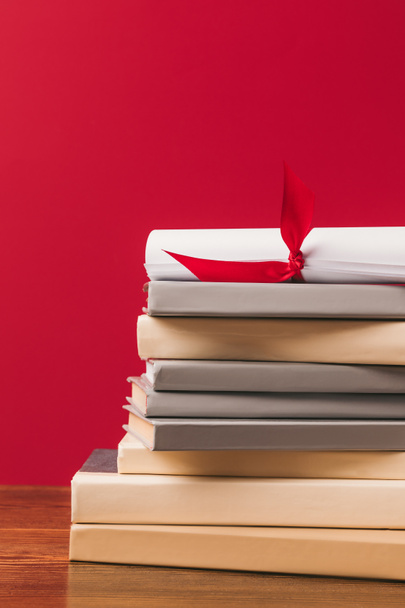Imagen recortada del diploma en la parte superior de la pila de libros en rojo
 - Foto, Imagen