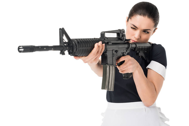 Brunette woman in maid uniform aiming gun isolated on white - Photo, Image