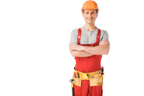 Cheerful construction worker in uniform with folded arms isolated on white - Photo, Image
