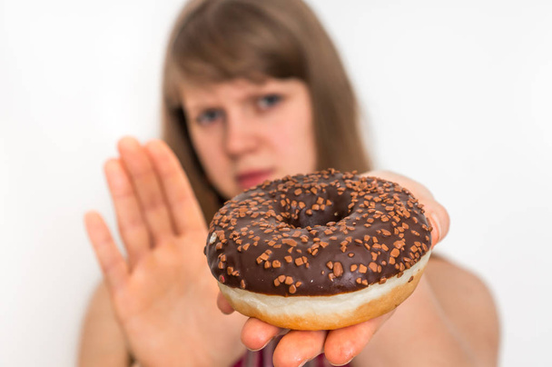 Woman refuses to eat donut - dieting concept - Foto, imagen