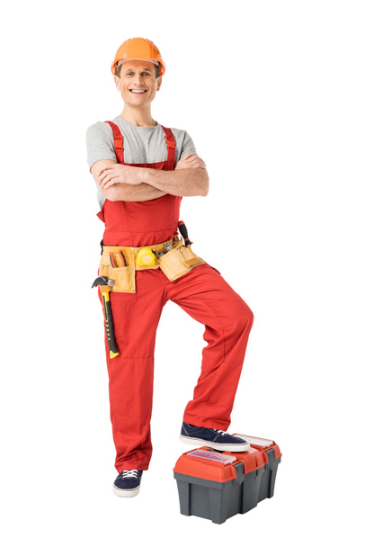 Builder with tools in belt standing with folded arms isolated on white - Photo, Image