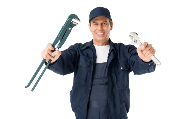 Professional plumber in overalls holding wrenches isolated on white - Zdjęcie, obraz