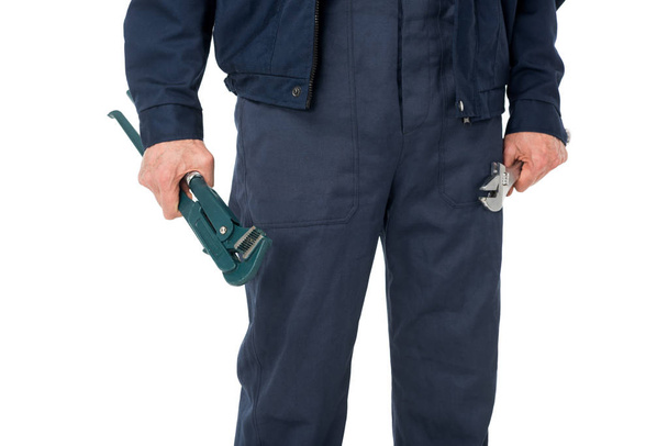 Close-up view of plumber  holding adjustable wrenches isolated on white - Φωτογραφία, εικόνα