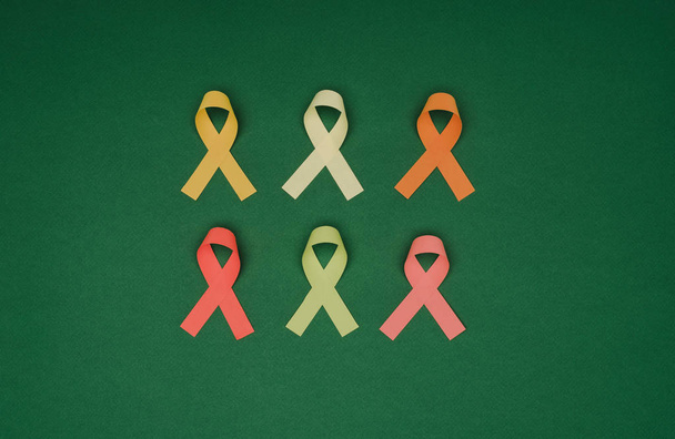 top view of arrangement of colorful ribbons isolated on green surface, world health day concept - Foto, Imagen