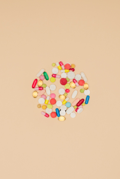 pohled shora z léků, které jsou uspořádány v kruhu izolované na béžové, koncepce Světový den zdraví - Fotografie, Obrázek