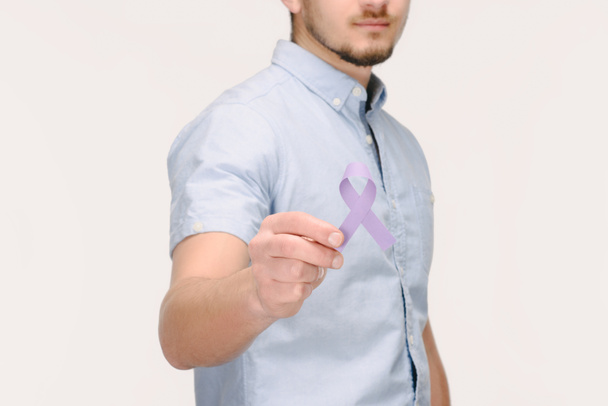 cropped shot of man showing purple awareness ribbon for general cancer awareness, Lupus awareness, drug overdose, domestic violence symbol isolated on white - Photo, Image