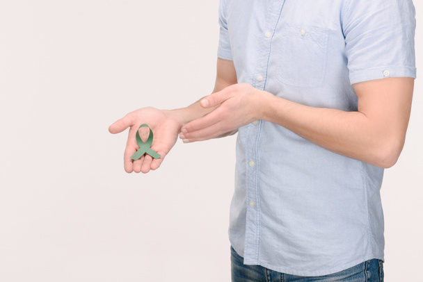Γήρανση περικοπεί shot δείχνει κορδέλα πράσινο ευαισθητοποίηση για τον καρκίνο των επινεφριδίων του ανθρώπου, την έρευνα ευαισθητοποίηση, διπολική διαταραχή, που απομονώνονται σε λευκό - Φωτογραφία, εικόνα