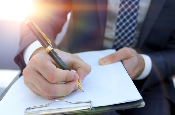 Επιχειρηματίας υπογράφει μια σύμβαση. Κρατώντας το στυλό στο χέρι. - Φωτογραφία, εικόνα