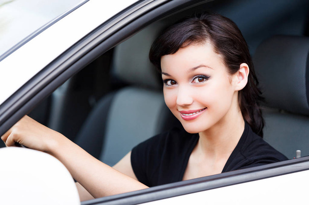 Счастливый владелец новой машины. Молодая красивая женщина водитель улыбается вам
 - Фото, изображение