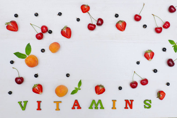 Inscrição colorida Vitaminas. Frutas e espaço de cópia. Fundo branco. Conceito alimentar
 - Foto, Imagem