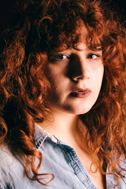 Portrait of a beautiful girl with curly red hair - Фото, зображення
