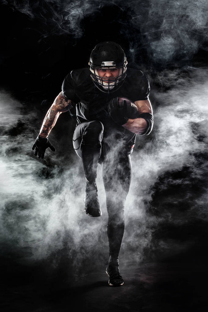American football sportsman player isolated on black background - Фото, зображення