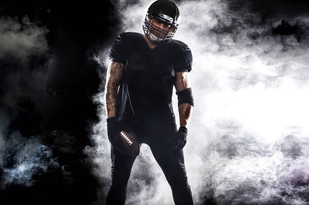 American football sportsman player isolated on black background - 写真・画像