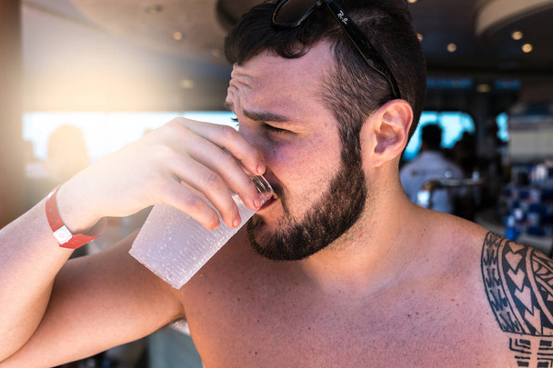 Uomo che beve alla festa in piscina in nave da crociera
 - Foto, immagini