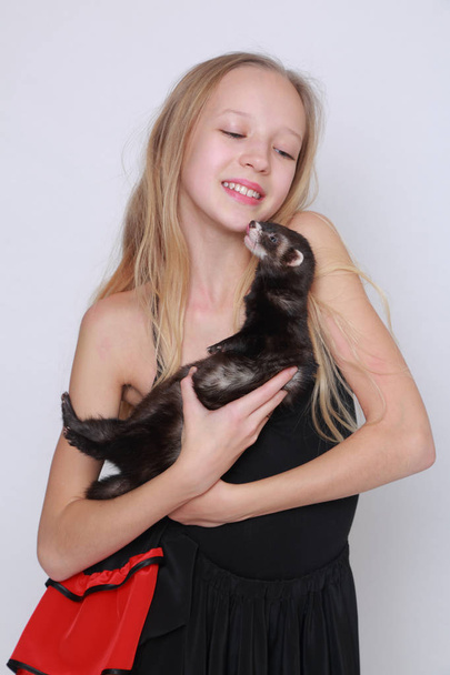 Studio image of caucasian little girl and ferret over white backgoud - Foto, Imagen