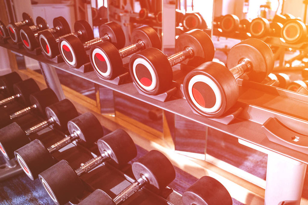 fitness and workout equipment: set of the modern dumbbells on the rack - Foto, Imagen