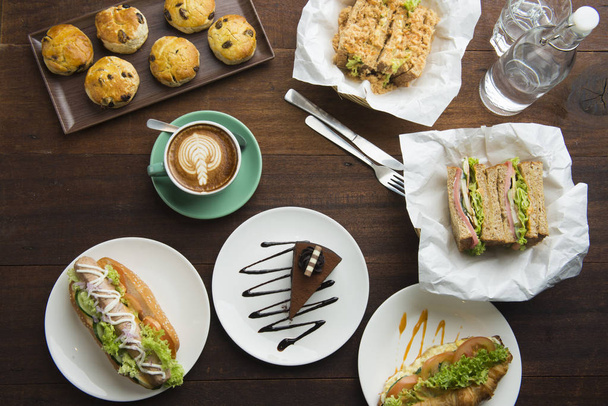 Different types of coffee and food on dark table, top view - 写真・画像
