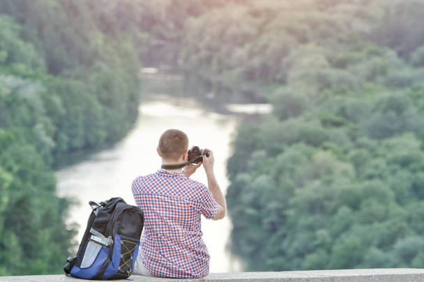 Człowiek robi zdjęcia z górki. Lasu i rzeki poniżej - Zdjęcie, obraz