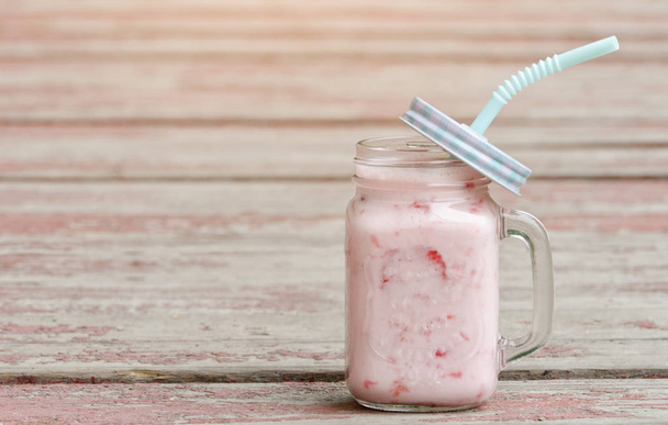 Muki jogurttia ja mansikoita punaisella taustalla vintage puulaudat
 - Valokuva, kuva