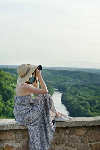 Dziewczyna w sukienkę i kapelusz z kamerą. Hill, zielonego lasu i rzeki poniżej - Zdjęcie, obraz