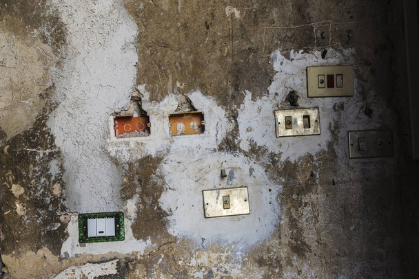 Световые выключатели, размещенные хаотично на стене в Палермо, Италия
 - Фото, изображение
