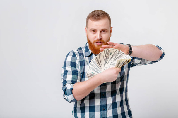 man with beard holding lot of hundred-dollar bills - Foto, Imagen