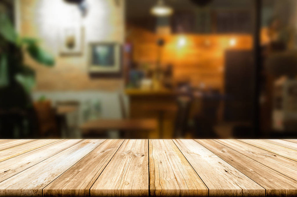 Empty wooden table top with blur coffee shop or restaurant interior background. - Foto, Imagem