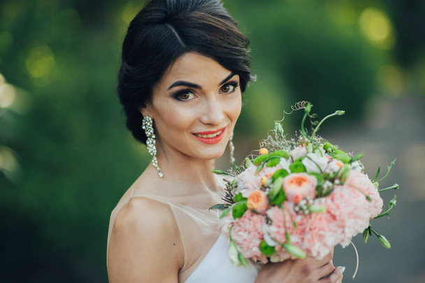 Tender bride posing with wedding bouquet - Foto, Imagen