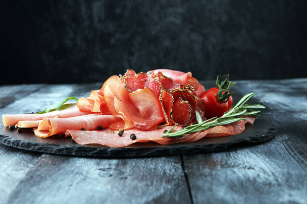Plateau alimentaire avec délicieux salami, morceaux de jambon tranché, saucisse,  - Photo, image