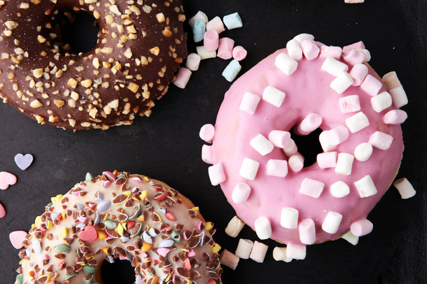 erilaisia donitseja suklaa himmeä, vaaleanpunainen lasitettu ja ripottele
 - Valokuva, kuva