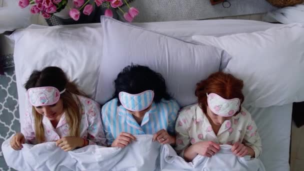Vista superior, tres hermosas chicas se van a la cama y se ponen vendajes para dormir después de la noche de despedida de soltera y una gran fiesta
. - Imágenes, Vídeo