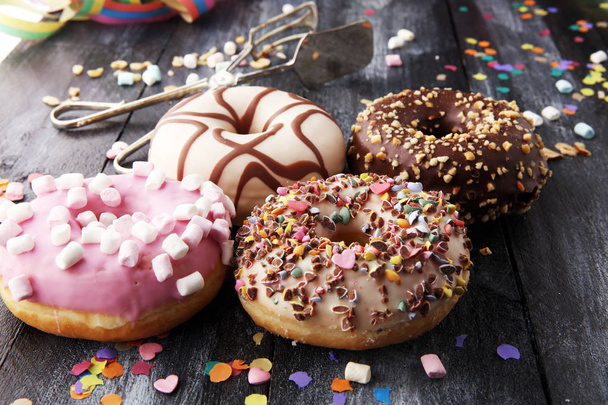 erilaisia donitseja suklaa himmeä, vaaleanpunainen lasitettu ja ripottele
 - Valokuva, kuva
