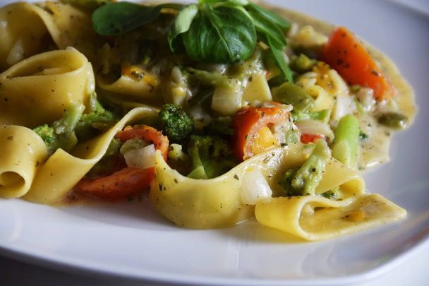 tagliatelle pasta with vegetables, cream-herb sauce, tomatoes - 写真・画像
