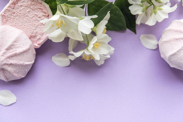 γκρο πλαν φωτογραφία γλυκό marshmallow ροζ με λευκή άνοιξη λουλούδια ανθίζουν σε μοβ φόντο - Φωτογραφία, εικόνα