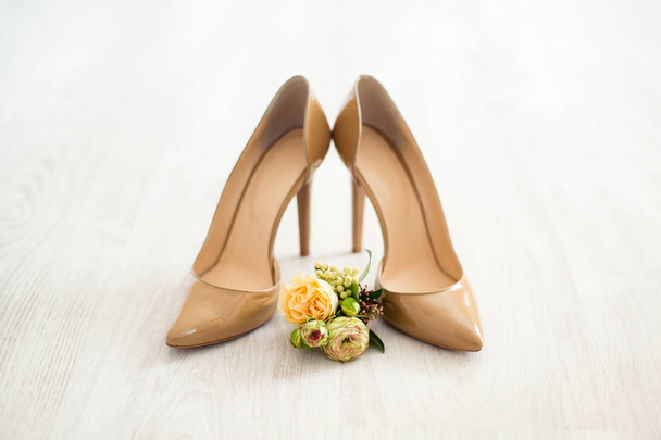 close-up of beautiful wedding flowers with beige shoes of bride on blurred background  - Фото, зображення