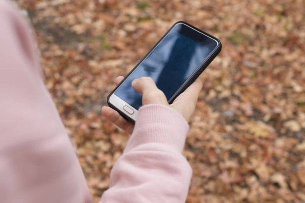jeune main avec téléphone portable à l'automne à l'extérieur
 - Photo, image