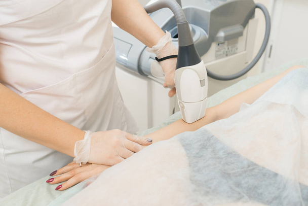 specialist makes client laser hair removal on hands - Zdjęcie, obraz