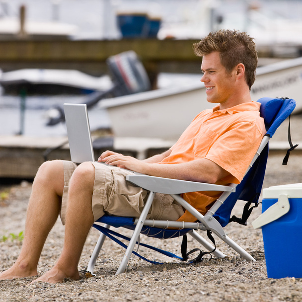 Homme utilisant un ordinateur portable sur la plage
 - Photo, image