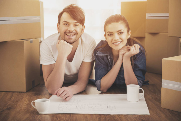 The young happy couple planning a new house. Moving, purchase of new habitation - 写真・画像